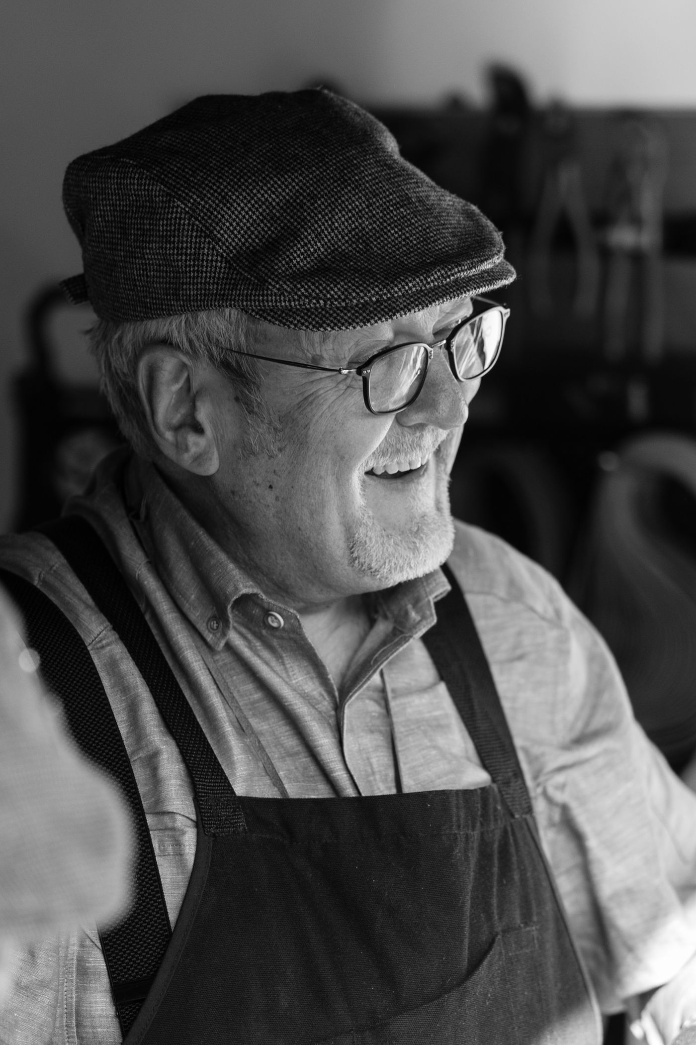 A smiling craftsman in an apron in his workshop